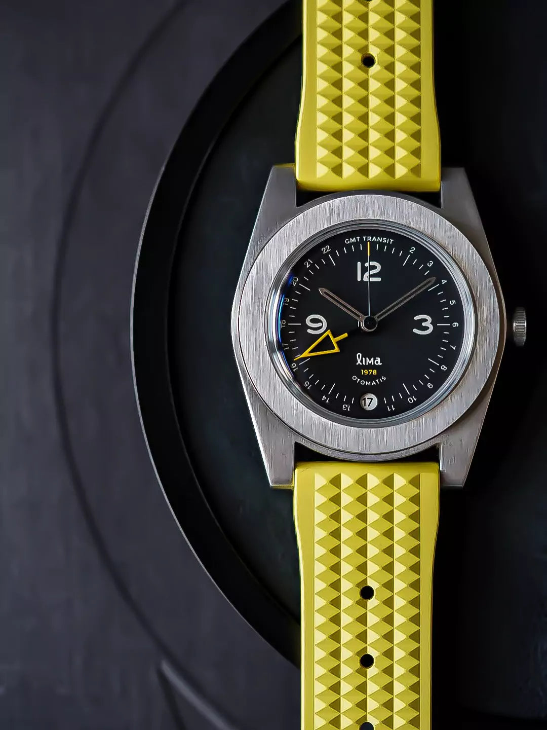 Yellow waffle style rubber strap on a black dial watch with yellow GMT hand